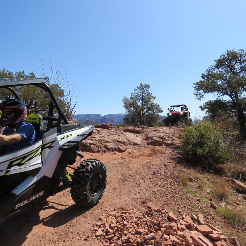 a man riding a motorcycle down a dirt road