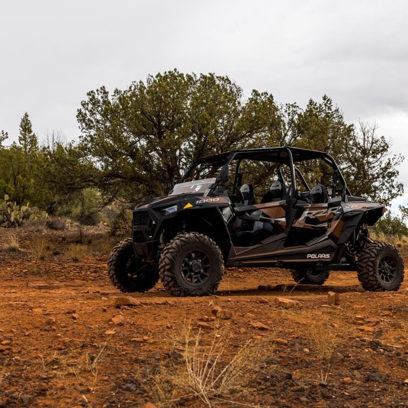a truck parked on the side of a dirt field