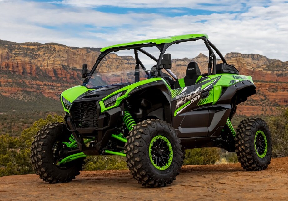 a green motorcycle parked on a dirt road